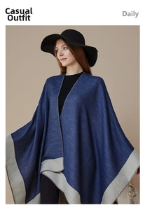 Detail of navy knit poncho wrap with light grey contrast borders and vertical texture