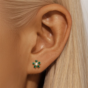 Detailed close-up of a s925 silver floral stud earring with green and white gems
