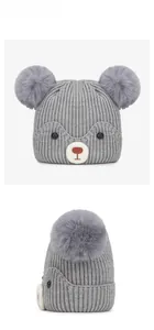Front and side view of grey baby knit beanie with cute bear face and twin pom-poms