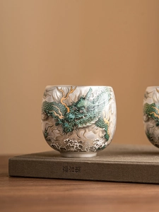 Detail of Chinese porcelain tea cup featuring intricate Azure Dragon and cloud pattern