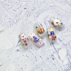 Detail of Nutcracker Christmas nail charms with glitter base and rhinestone accents