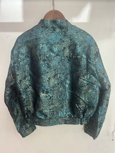 Rear view of a slim-fit blue and gold jacquard jacket with intricate metallic texture