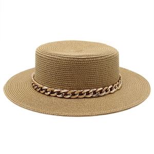 Detailed view of boater straw hat with natural texture and decorative gold chain trim