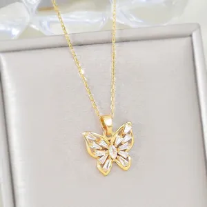 Elegant gold butterfly pendant necklace with cubic zirconia on a gray jewelry box