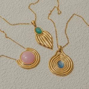 Detailansicht von drei Vintage-Goldketten mit grünen, rosa und blauen Edelsteinen