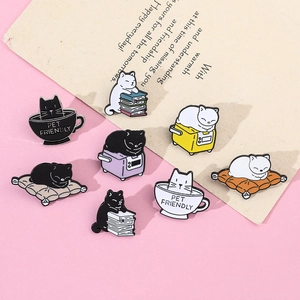 Detail of eight cute cat enamel pins featuring coffee, books, and TV on pink background