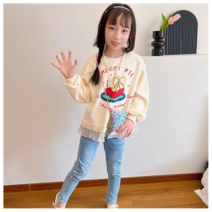Détail du sweat enfant crème avec imprimé cerise et ourlet en dentelle orné de perles