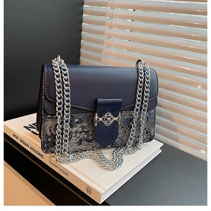 Detailed view of the navy blue chain shoulder bag with elegant patterned fabric bottom