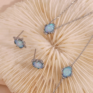 Détail d'un ensemble de bijoux argentés avec opales bleues et petits diamants blancs