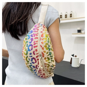 Detail of cross-body waist bag featuring vibrant colorful leopard print on woven fabric