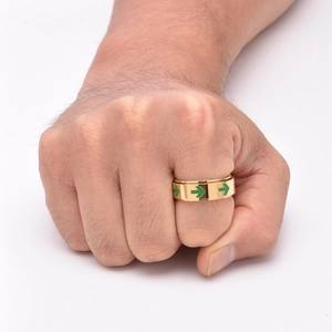 Close-up of golden rotating arrow ring with green luminous pattern on male hand