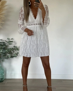 Close-up of white floral lace texture with flared sleeves and hollow waist detail