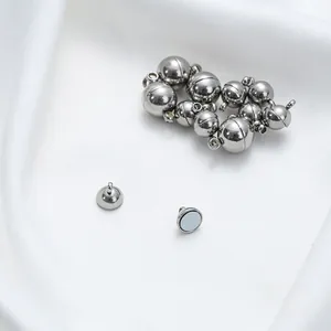 Detail of silver stainless steel magnetic clasps for DIY jewelry on white silk