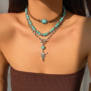 Close-up of bohemian layered necklace set with turquoise beads and bull head pendant