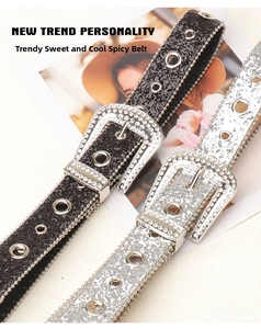 Close-up of black and silver sequin belts with rhinestone buckles and metal eyelets