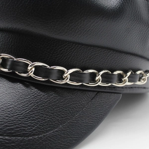 Detailed close-up of textured black PU leather hat with silver metal chain and woven strap