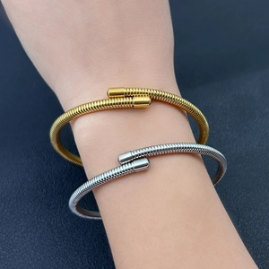 Detailed view of elastic spring bracelets in gold and silver finish on a wrist