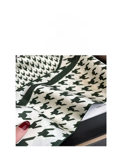 Detail view of green and white houndstooth silk scarf showing premium fabric texture