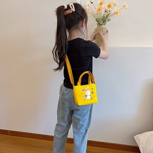 Girl wearing a yellow canvas crossbody bag with cute rabbit print in a lifestyle setting