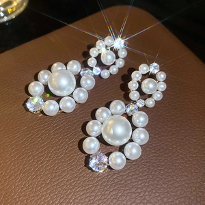 Vue détaillée des boucles d'oreilles perles et zircons avec design circulaire