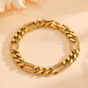 Detail of gold Cuban link bracelet featuring partial diamond pave and polished finish