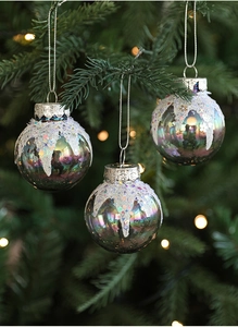 Close-up of iridescent Christmas balls with white glitter and sequins on a tree branch