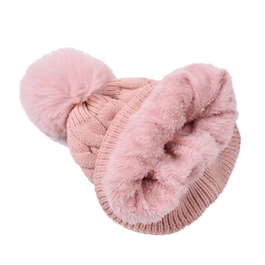Close-up of pink knit beanie with thick faux fur lining and large pom-pom detail