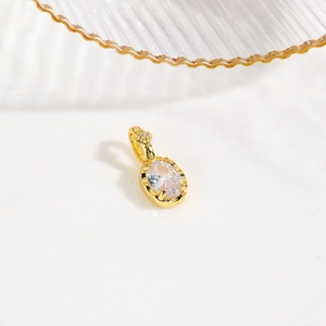 Detail of 18k gold plated turtle pendant with oval clear cubic zirconia stone