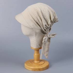 Detail view of beige cotton headband sun hat with side bow tie and breathable texture