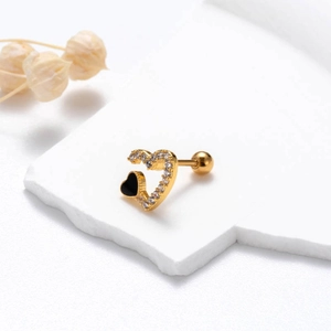 Macro detail of gold heart stud earring with clear zircon and black enamel finish