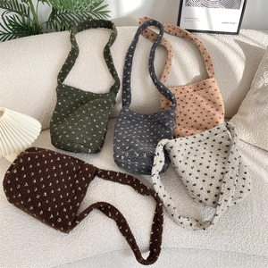 Sac seau en peluche à pois en cinq couleurs sur canapé avec déco chaleureuse