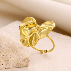Detailed view of an adjustable gold-plated leaf ring on a decorative stone