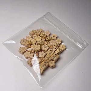 Vue détaillée de perles fleurs de prunier en buis naturel avec trou central pour bijoux DIY