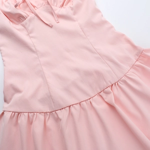 Gros plan détaillé de la taille de la robe rose montrant le plissage et la couture