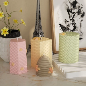 3D honeycomb texture candles with bee decor in pink, yellow and green pillars