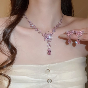 Close-up of pink zircon butterfly and teardrop tassel necklace and earrings set