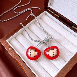 Macro detail of red enamel cherry pendant with sparkling rhinestones in a luxury box