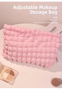 Detalle de neceser rosa con textura de burbujas y accesorios de viaje para la piel