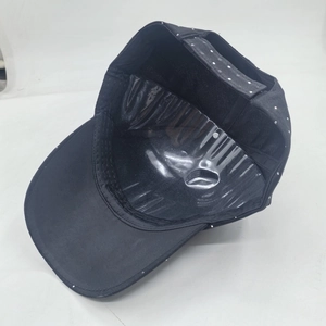 Detail of black baseball cap with white polka dots and adjustable rear buckle strap