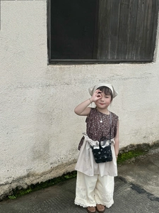 Detail of vintage woven hollow-out crossbody bag with floral sleeveless top for kids