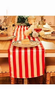 Elegant red and white striped table runner shown in a luxury dining setting with glassware