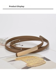 Detail of slim brown leather belt with matte gold rectangular buckle and fine stitching