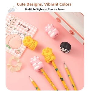 Close-up of cute cat paw pencil caps in pink and yellow on a notebook background
