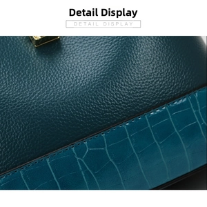 Detailed close-up of dark teal lychee grain and peacock blue crocodile embossed leather
