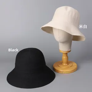 Detail of woven bucket hats in beige and black featuring breathable paper straw texture