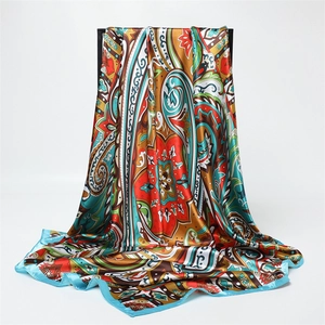 Close-up of colorful paisley silk scarf with glossy satin finish and blue rolled edges