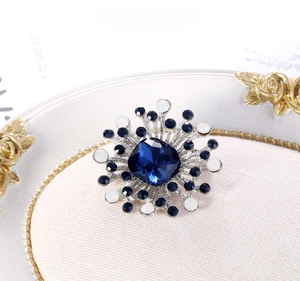 Macro shot of geometric blue crystal brooch with silver branches and white pearls