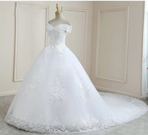 Close-up of off-the-shoulder wedding dress with lace appliques and cathedral train