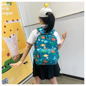 Rear view of a child wearing the dinosaur print backpack with adjustable straps