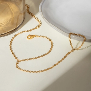 Detail of minimalist gold slave bracelet with zircon and pearls featuring a lobster clasp